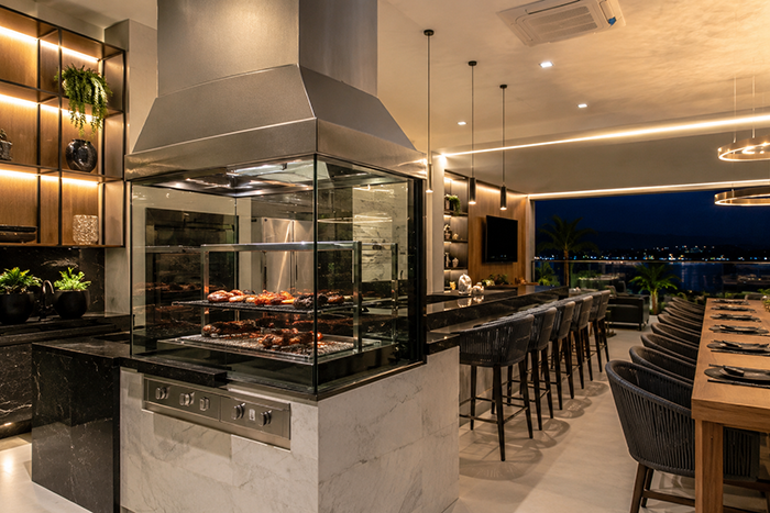 Área gourmet de alto padrão com churrasqueira de vidro e inox, acabamento impecável, design contemporâneo, ambiente clean e sofisticado, fotografia arquitetônica profissional, ultra HD, 8K.